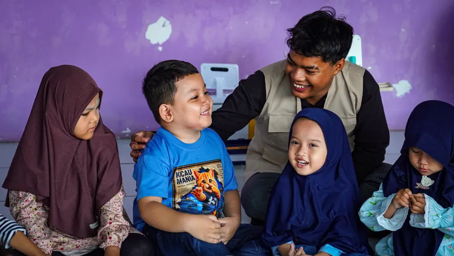 Anak-anak tertawa bersama relawan