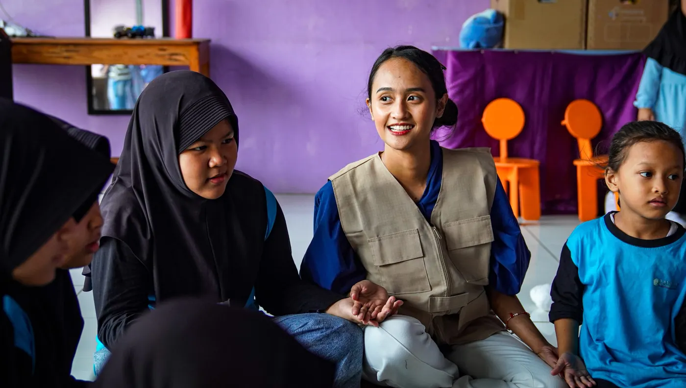 Relawan duduk dan bercerita bersama anak-anak
